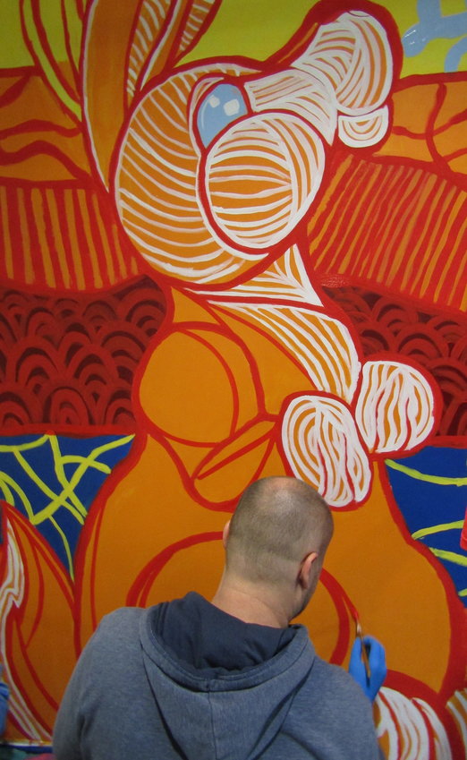 Professional muralist Daniel Crosier adds details to the jackalope.